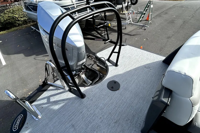 Slide: The Image of 2026 Godfrey Monaco 235 ULC pontoon boat with Honda outboard motor, docked on pavement. - 3