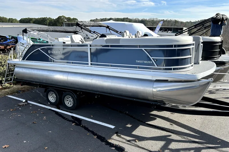 Slide: The Image of 2026 Godfrey Sweetwater 2286 SFL pontoon boat on trailer, parked outdoors. - 0