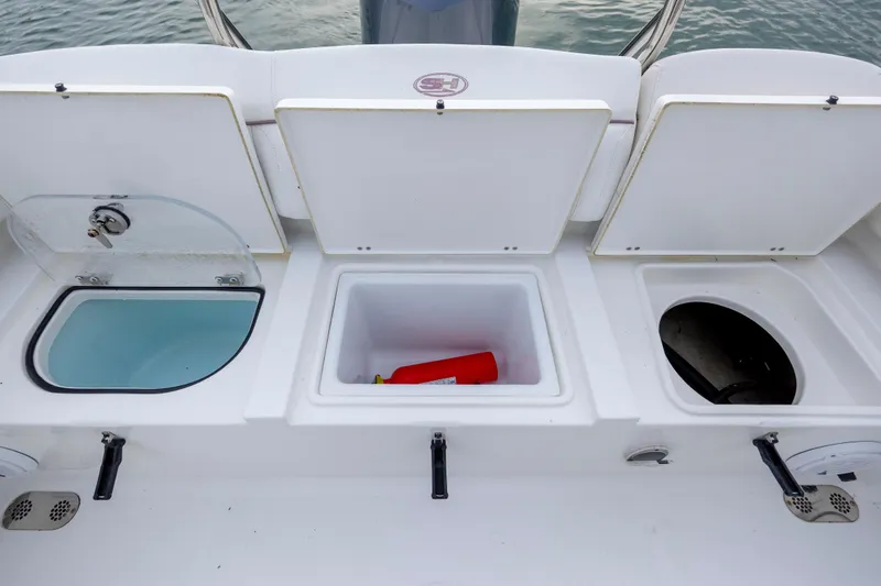 Slide: The Image of 2018 Sea Hunt Ultra 255 SE boat storage compartments with open lids, showing interior details. - 12