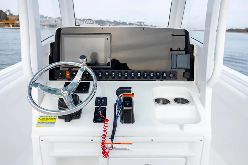 Slide: The Image of 2018 Sea Hunt Ultra 255 SE boat console with steering wheel and controls. - 13