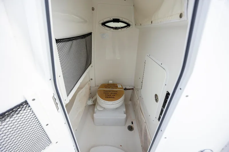 Slide: The Image of 2018 Sea Hunt Ultra 255 SE boat interior with compact marine toilet. - 16