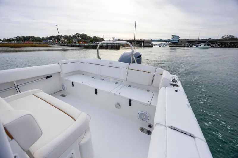 Slide: The Image of 2018 Sea Hunt Ultra 255 SE boat with spacious seating on calm water. - 8