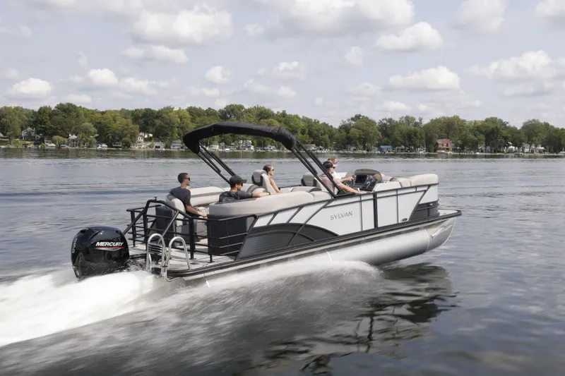 Slide: The Image of 2026 Sylvan L-3 ULZ pontoon boat cruising on a serene lake. - 2