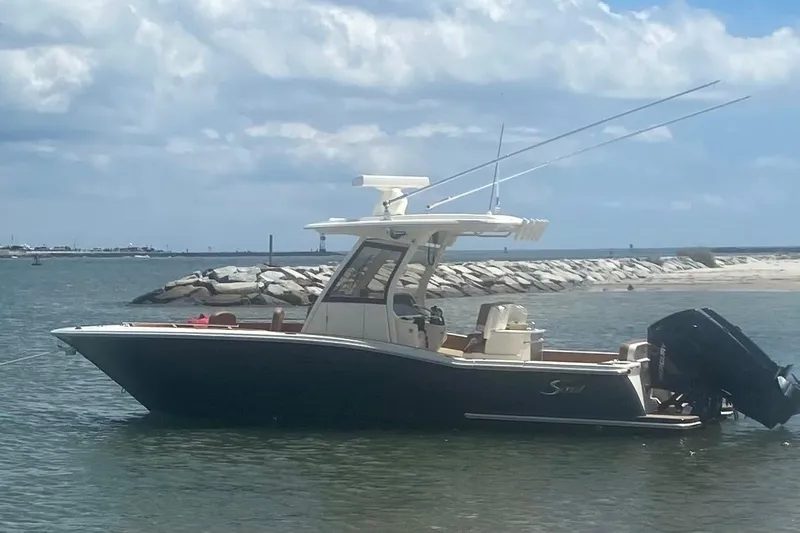 Slide: The Image of 2023 Scout 277 LXF boat docked by waterfront homes. - 3