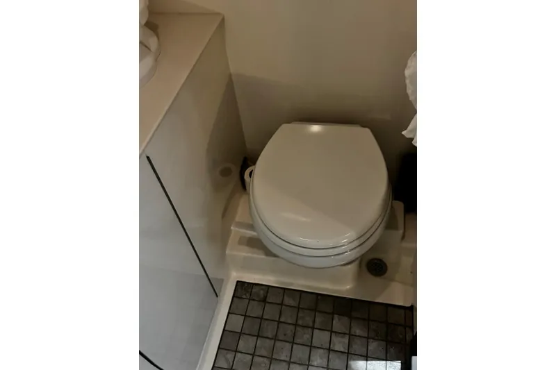 Slide: The Image of 2022 Sea Ray Sundancer 320 Outboard bathroom with compact toilet and tiled floor. - 16