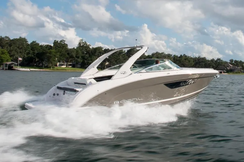 The Image of 2026 Regal 3300 boat displayed at an indoor boat show with seating area. - 0