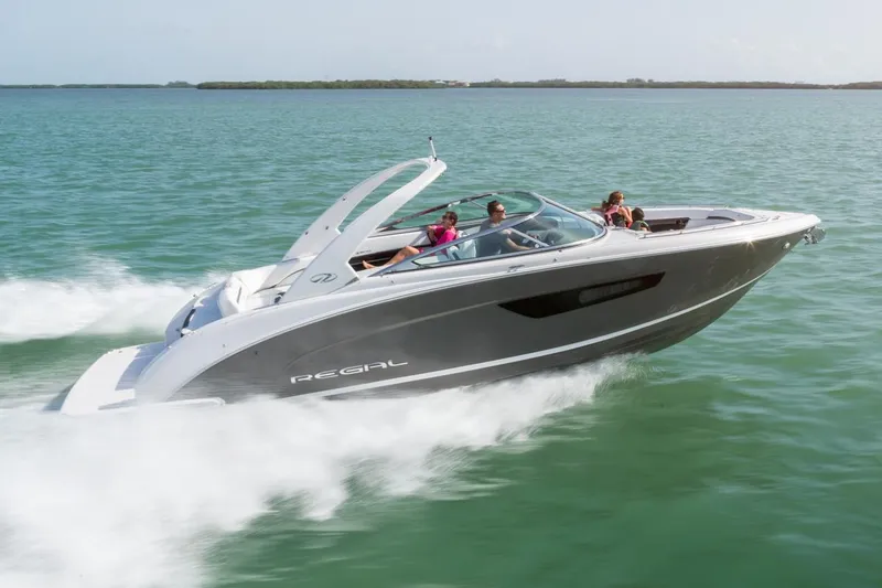Slide: The Image of 2026 Regal 3300 boat displayed at an indoor expo, showcasing sleek design and spacious seating. - 3