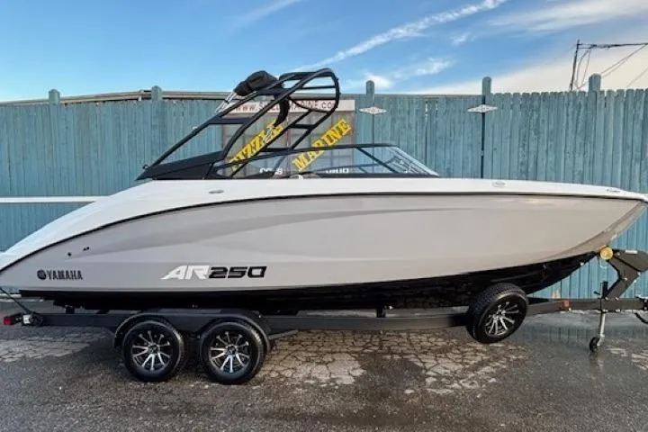 The Image of 2026 Yamaha Boats AR250 on trailer, sleek design, parked outdoors. - 0