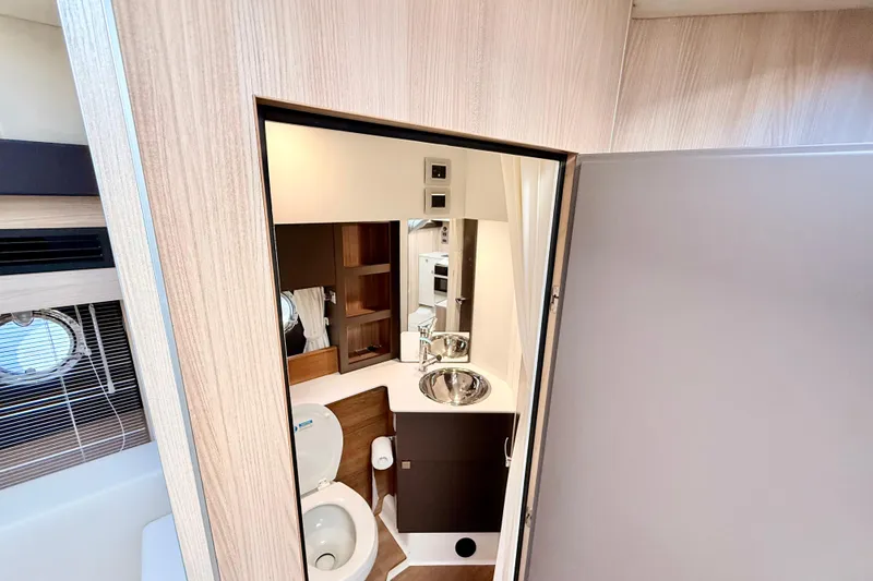 Slide: The Image of 2016 Cranchi M44 HT yacht bathroom with modern toilet and wooden accents. - 114