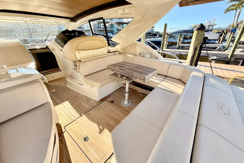 Slide: The Image of 2016 Cranchi M44 HT yacht interior with seating, table, and waterfront view. - 13
