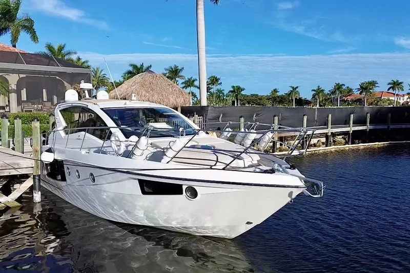 Slide: The Image of 2016 Cranchi M44 HT yacht docked in a tropical marina setting. - 2