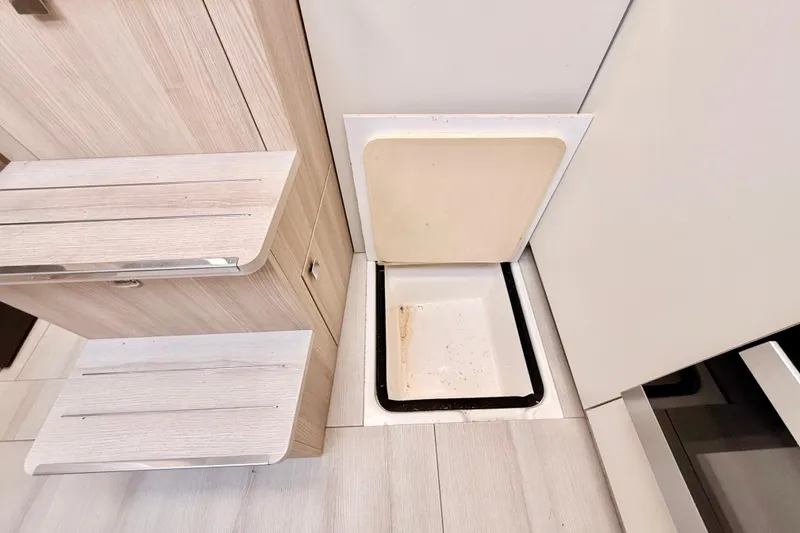 Slide: The Image of Interior view of 2016 Cranchi M44 HT yacht, featuring sleek cabinetry and a porthole window. - 57