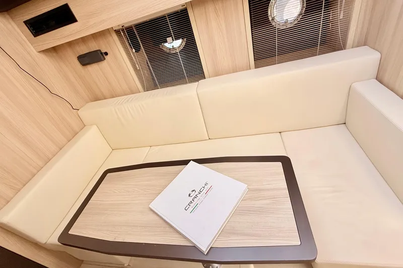 Slide: The Image of Luxurious interior of 2016 Cranchi M44 HT yacht with beige seating and wooden table. - 86