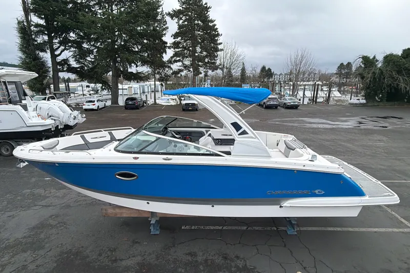 The Image of 2018 Chaparral 267 SSX boat with blue hull and canopy in a marina setting. - 0