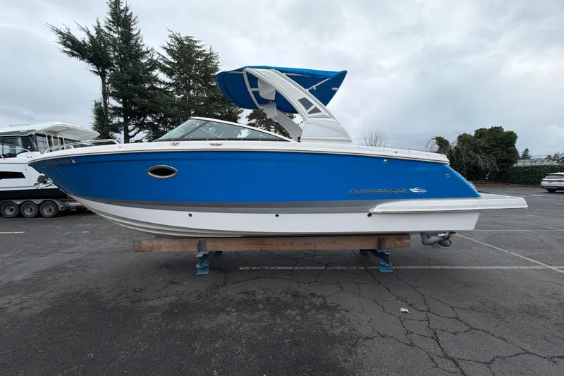 Slide: The Image of 2018 Chaparral 267 SSX boat in vibrant blue, parked on a trailer. - 1