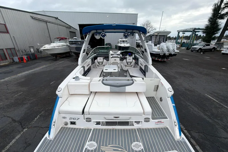 Slide: The Image of 2018 Chaparral 267 SSX boat with spacious seating, docked at a marina. - 11