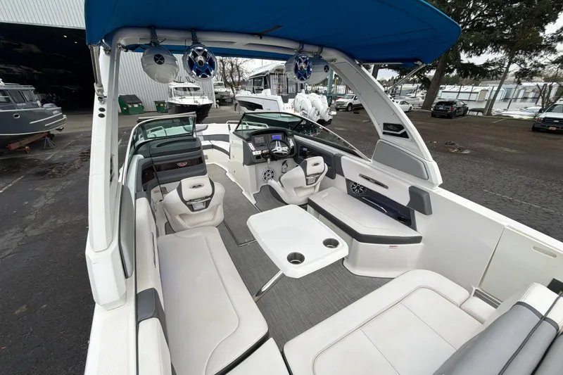 Slide: The Image of 2018 Chaparral 267 SSX boat interior with seating, table, and blue canopy. - 13