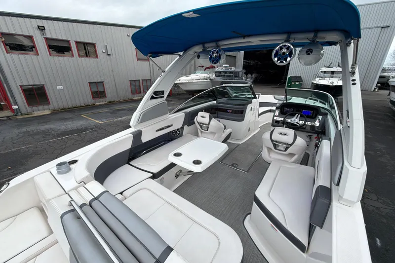 Slide: The Image of 2018 Chaparral 267 SSX boat interior with seating, helm, and blue canopy. - 15