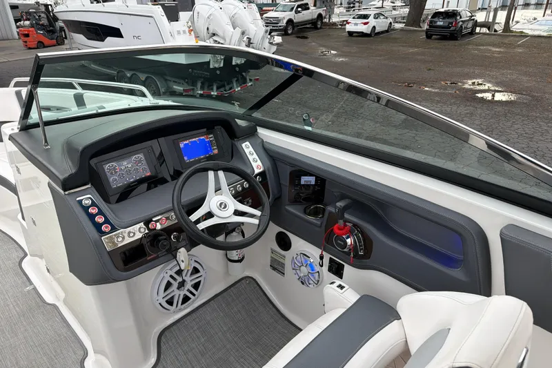 Slide: The Image of 2018 Chaparral 267 SSX boat dashboard with steering wheel and control panel. - 17