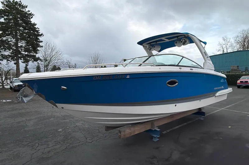 Slide: The Image of 2018 Chaparral 267 SSX boat in blue and white, parked outdoors on a stand. - 2