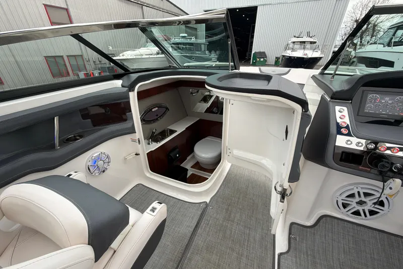 Slide: The Image of 2018 Chaparral 267 SSX boat interior with helm, seating, and cabin area. - 23