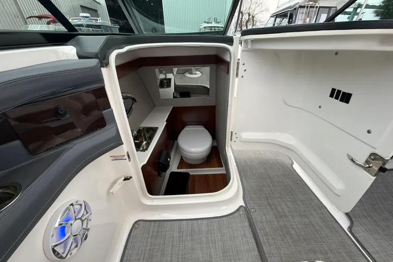 Slide: The Image of 2018 Chaparral 267 SSX boat interior with compact bathroom and modern amenities. - 24