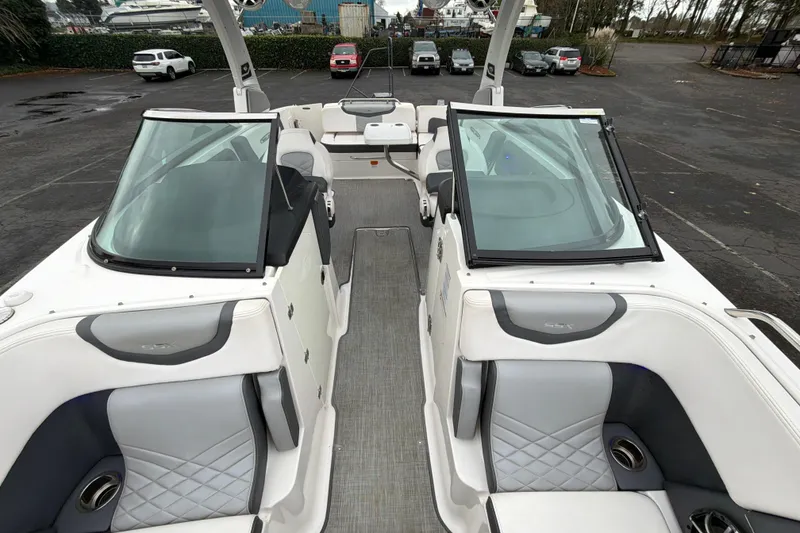 Slide: The Image of 2018 Chaparral 267 SSX boat interior with dual windshields and seating in a parking lot. - 29