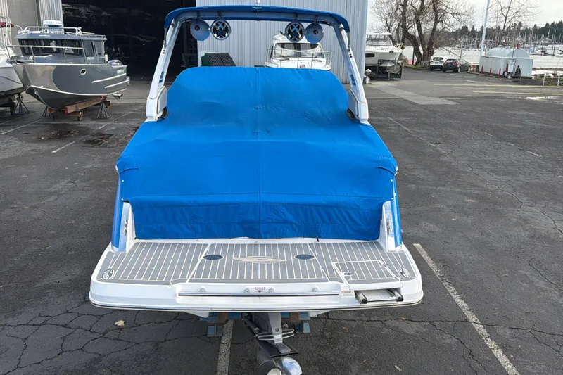 Slide: The Image of 2018 Chaparral 267 SSX boat with blue cover in a marina parking lot. - 39