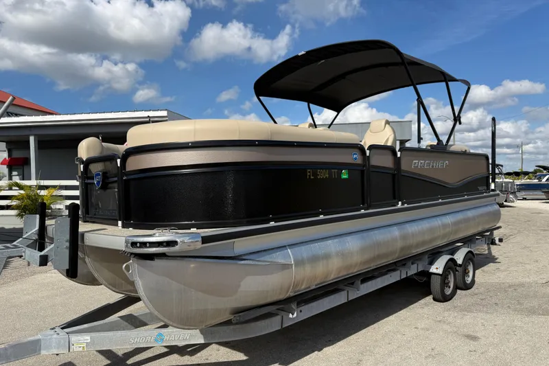 The Image of 2024 Premier Sunspree pontoon boat on trailer under blue sky. - 1