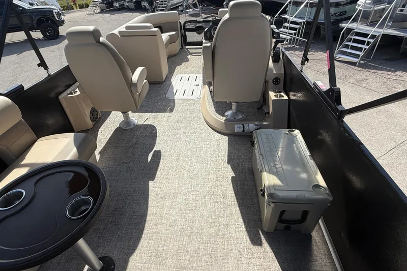 Slide: The Image of 2024 Premier Sunspree boat interior with beige seating and a cooler on deck. - 12