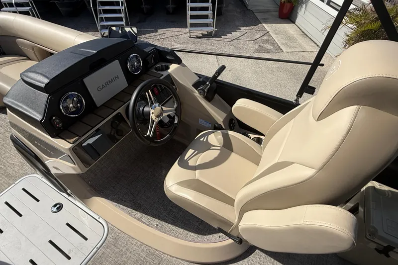 Slide: The Image of 2024 Premier Sunspree boat interior with Garmin navigation, beige seating, and modern dashboard. - 14