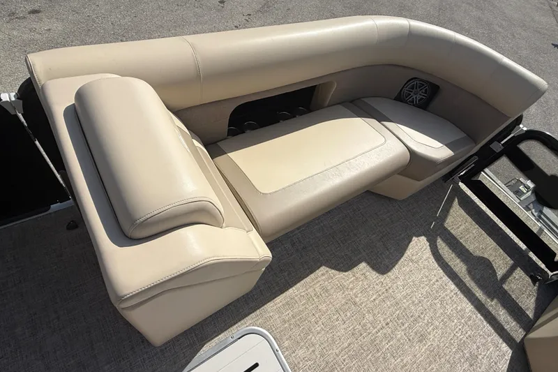 Slide: The Image of 2024 Premier Sunspree boat interior with beige seating and integrated speaker. - 16