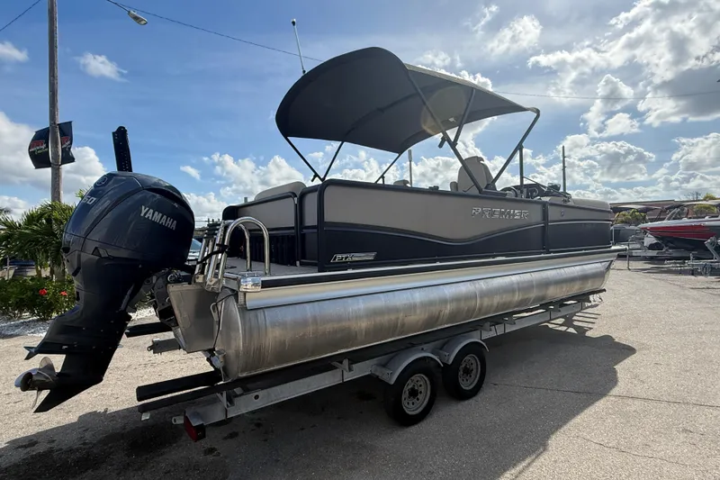 Slide: The Image of 2024 Premier Sunspree pontoon boat with Yamaha engine on a trailer, under a sunny sky. - 6