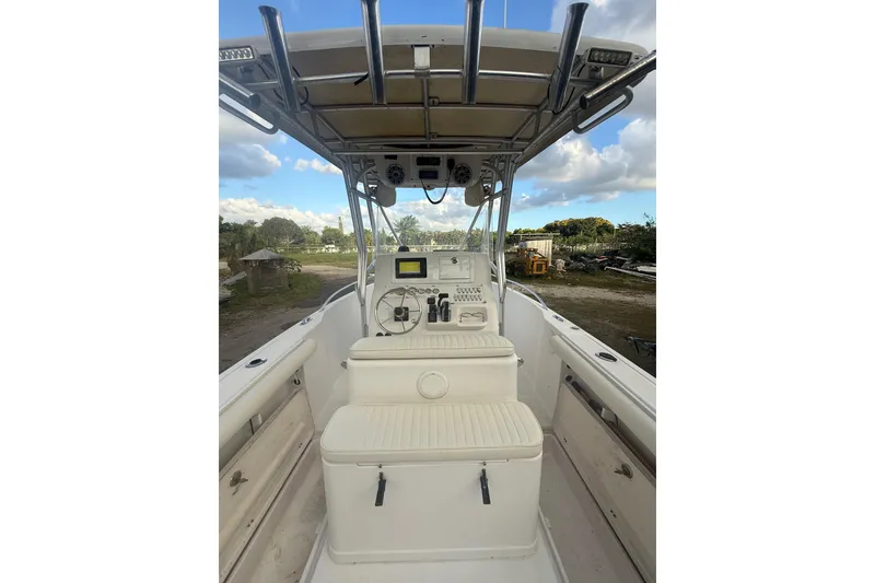 Slide: The Image of 2005 Pro-Line 24 Sport boat with center console and seating, parked outdoors. - 11