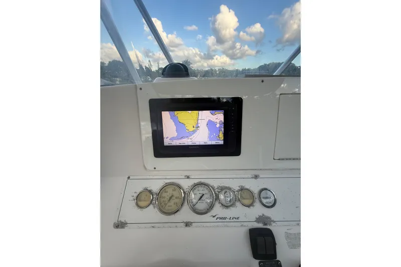 Slide: The Image of 2005 Pro-Line 24 Sport boat interior with white seating and control panel. - 14