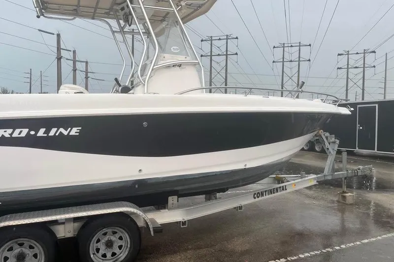 Slide: The Image of 2005 Pro-Line 24 Sport boat on trailer, parked outdoors under clear blue sky. - 3
