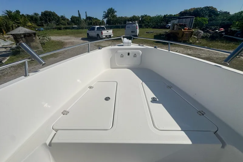 Slide: The Image of 2005 Pro-Line 24 Sport boat deck with storage compartments, parked outdoors. - 34