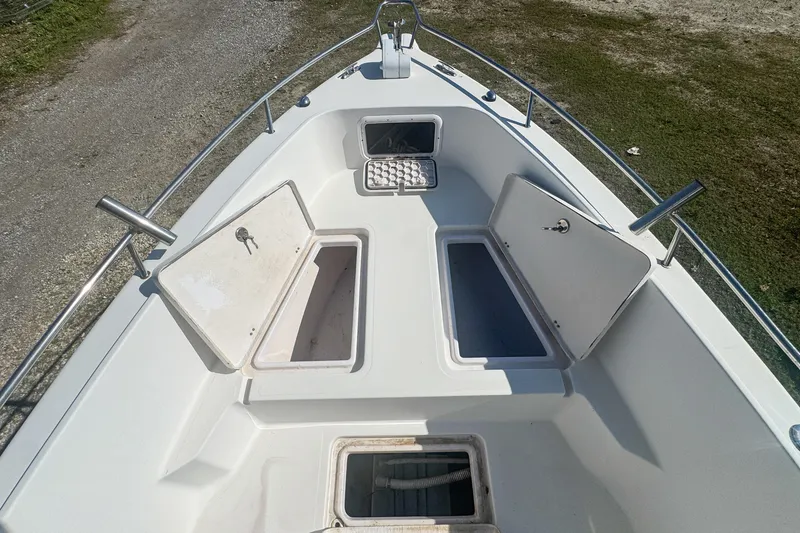 Slide: The Image of 2005 Pro-Line 24 Sport boat deck with open storage compartments. - 38