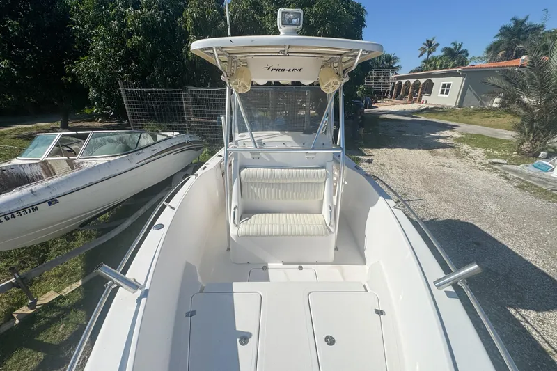 Slide: The Image of 2005 Pro-Line 24 Sport boat with seating, parked outdoors on a sunny day. - 41