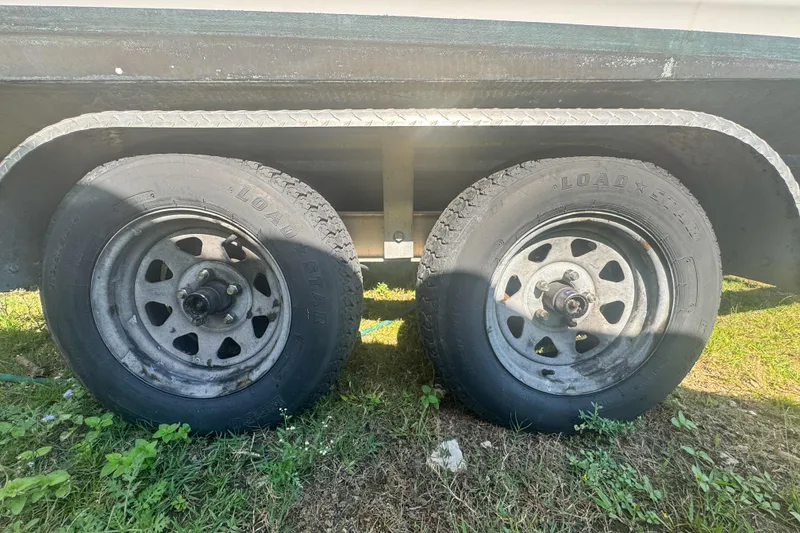 Slide: The Image of Trailer wheels of a 2005 Pro-Line 24 Sport boat on grass. - 43