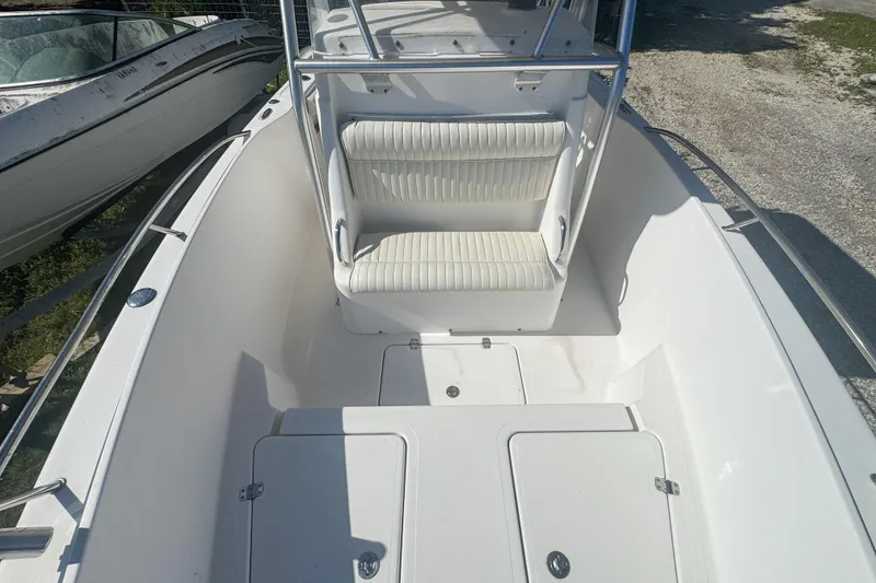 Slide: The Image of 2005 Pro-Line 24 Sport boat interior with white seating and storage compartments. - 46