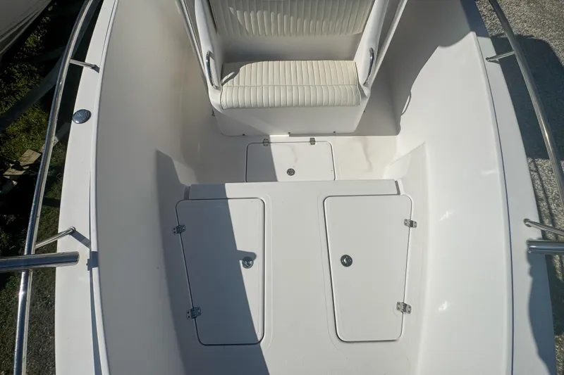 Slide: The Image of 2005 Pro-Line 24 Sport boat interior with white seating and storage compartments. - 47