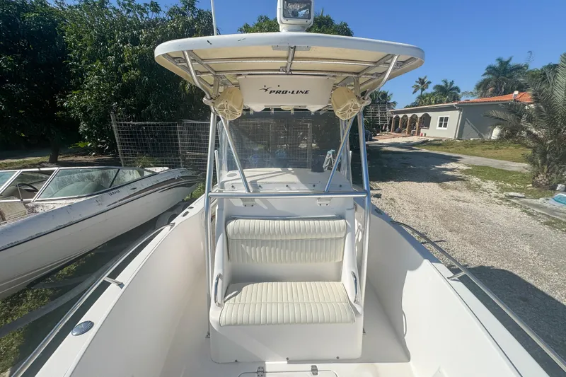 Slide: The Image of 2005 Pro-Line 24 Sport boat with seating, parked outdoors on a sunny day. - 48