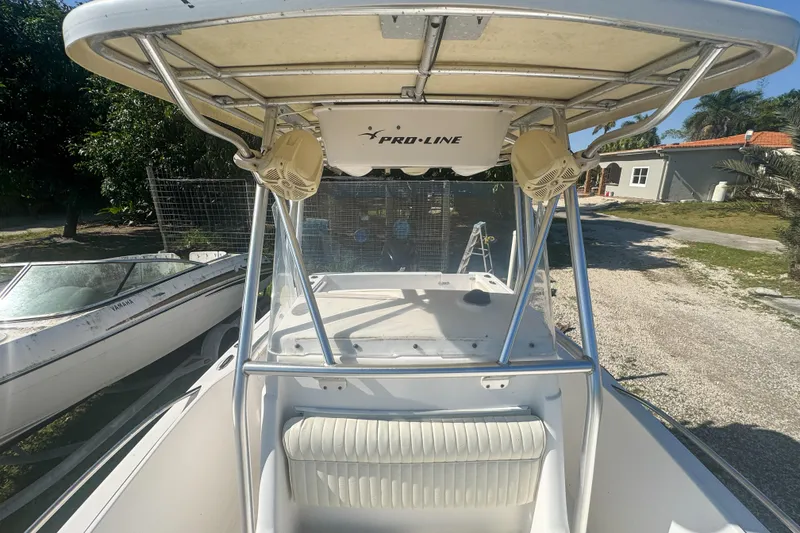 Slide: The Image of 2005 Pro-Line 24 Sport boat with T-top and seating, parked outdoors. - 51
