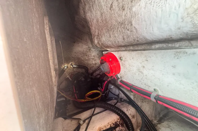 Slide: The Image of 2005 Pro-Line 24 Sport boat wiring and battery switch in compartment. - 69