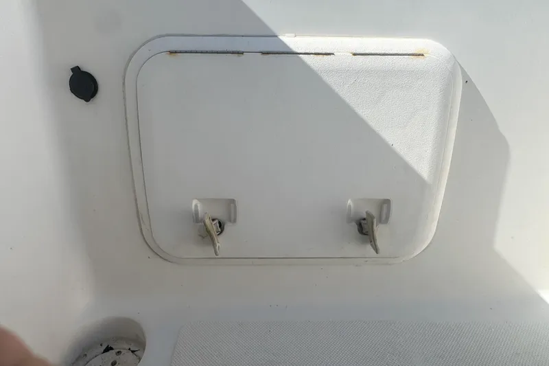 Slide: The Image of 2005 Pro-Line 24 Sport boat storage compartment with latches and shadow. - 71