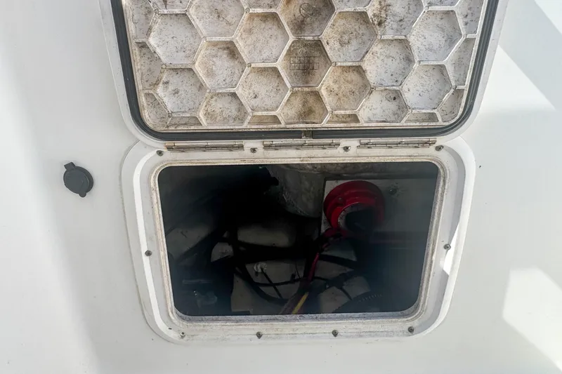 Slide: The Image of Open hatch on 2005 Pro-Line 24 Sport boat, revealing interior compartment. - 72