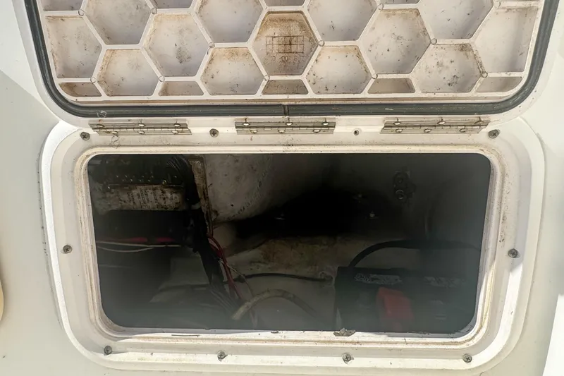 Slide: The Image of Open storage compartment on a 2005 Pro-Line 24 Sport boat, showing interior wiring. - 75