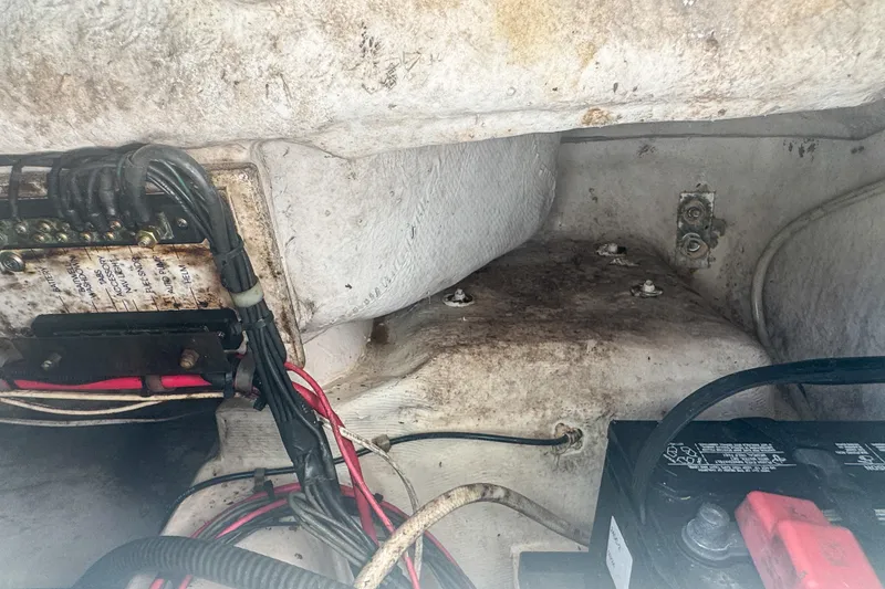 Slide: The Image of 2005 Pro-Line 24 Sport boat wiring and battery compartment, showing cables and connections. - 76