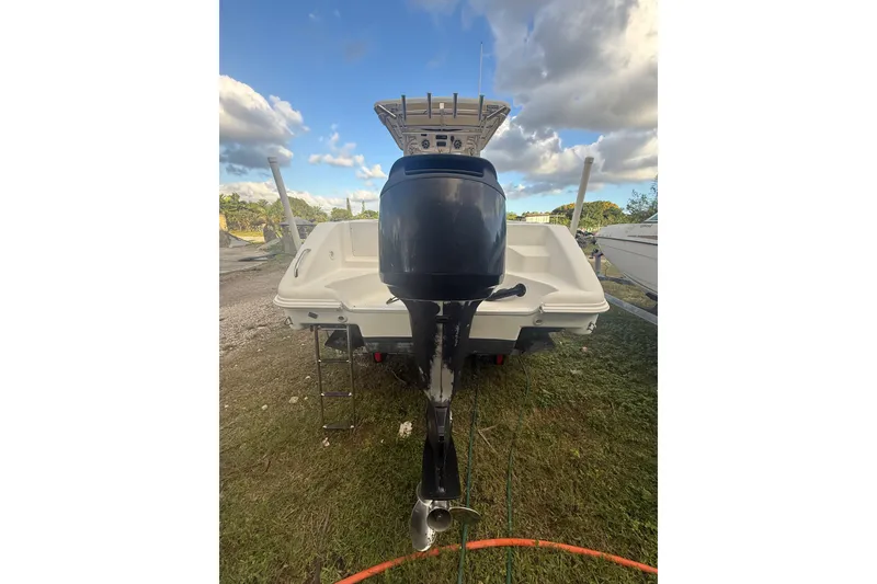 Slide: The Image of 2005 Pro-Line 24 Sport boat with outboard motor, parked on grass. - 8